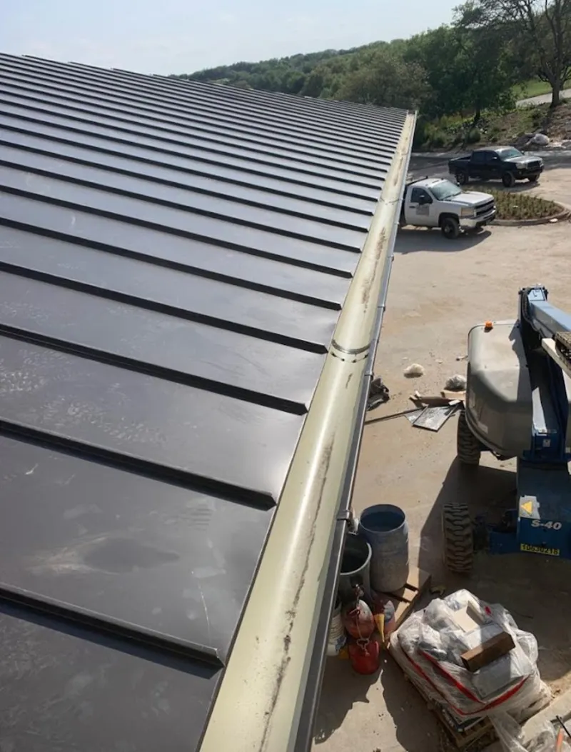 Standing seam panel and gutter detail on a metal roofing jobsite in Mobile